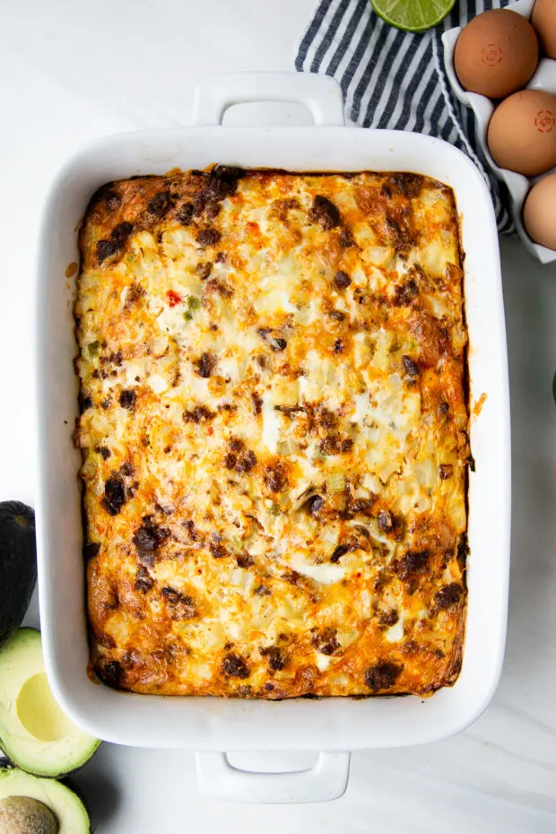 Baked hashbrown breakfast casserole in a white baking dish.