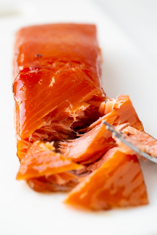 Piece of smoked salmon with the end pulled apart with a work.