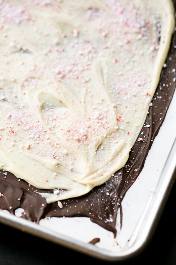 A layer of white chocolate added to the firmed dark chocolate with crushed candy canes all over the top.