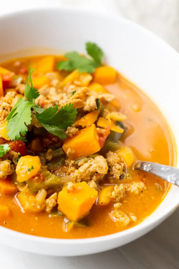 White bowl with Moroccan Paleo Turkey Chili garnished with fresh cilantro.