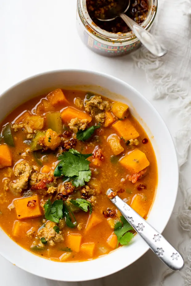 A bowl of the chili with some spicy chili crunch sprinkled on it.