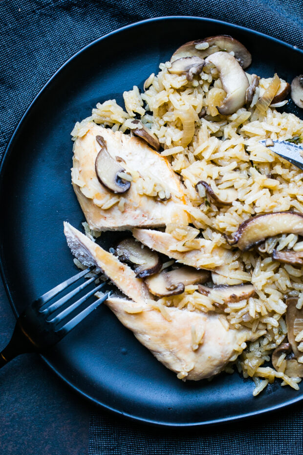 Another shot of the chicken breast being cut into slices next to the mushroom rice.