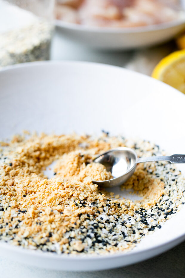 White bowl with cracker crumbs and everything bagel seasoning.