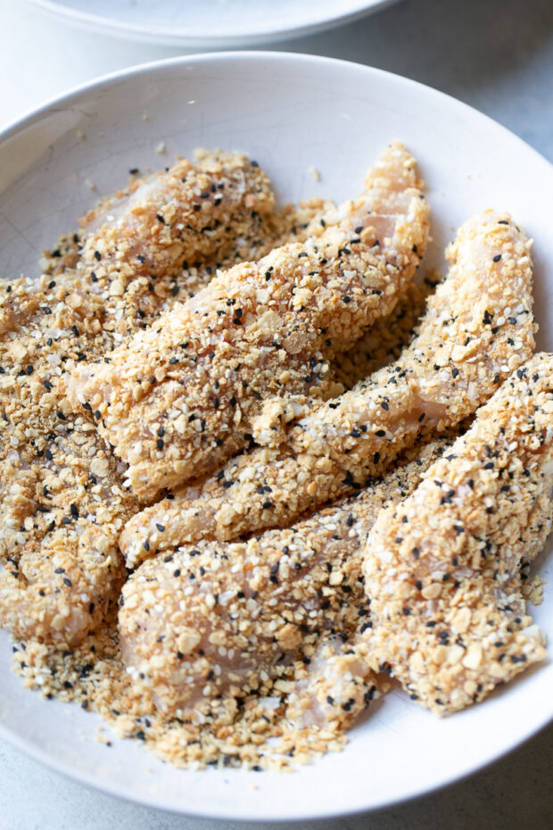 Chicken tenders that have been coated in the cracker mixture.