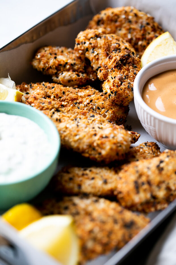 Alternate view of chicken tenders in serving tin with dipping sauces.