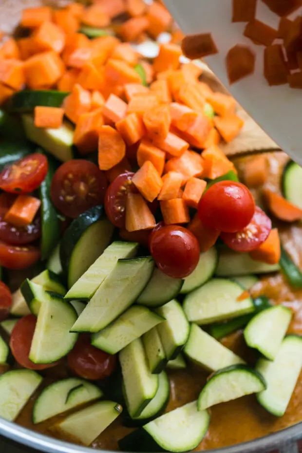 Vegetables going into the curry: small diced carrots, halved cherry tomatoes, sliced zucchini, and bell peppers.