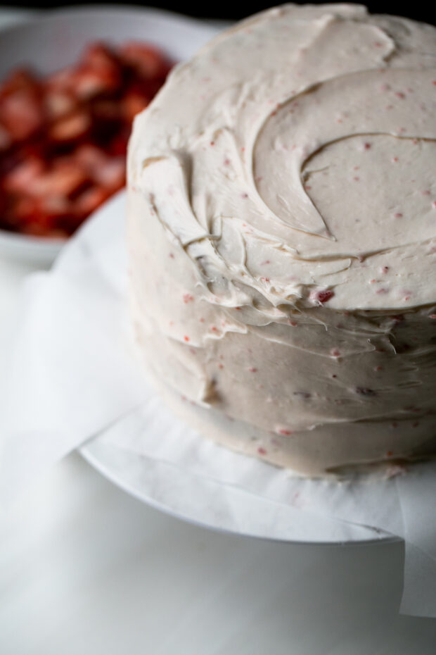 View of the whole cake covered with strawberry buttercream.