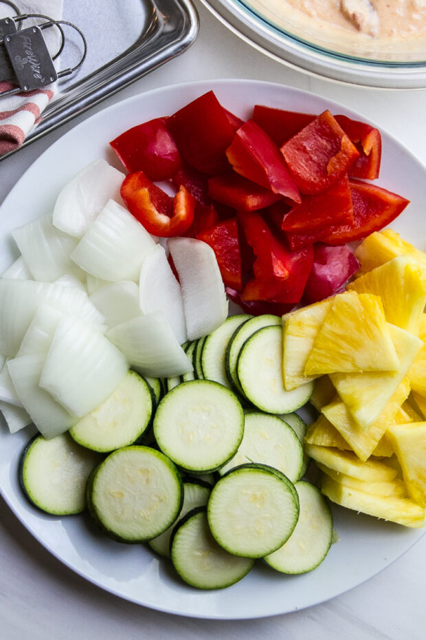 Vegetables to thread onto steak kebabs -- thinly sliced zucchini, pineapple, onion, and red bell peppers.