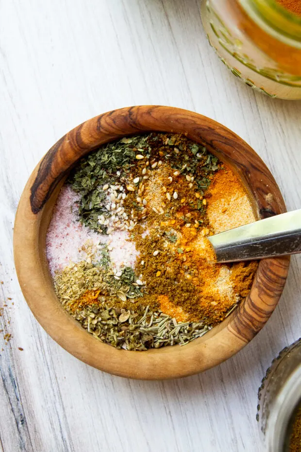 A small wooden bowl with the ingredients for Middle Eastern Seasoning not quite mixed up all the way.