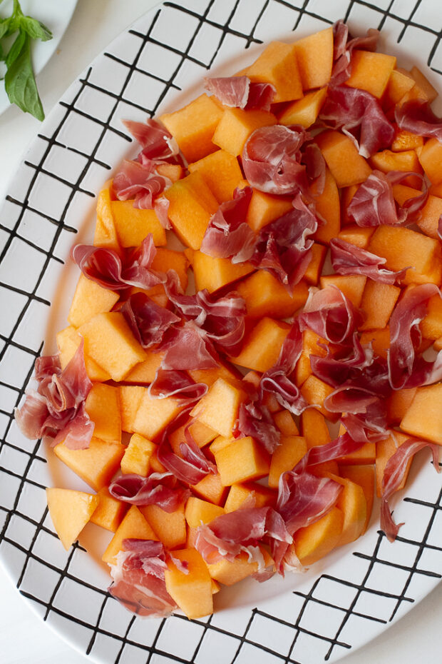 The serving platter with only the cantaloupe and prosciutto.