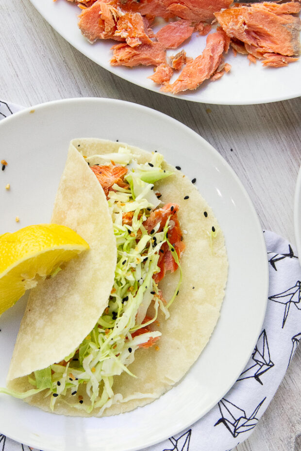 Smoked Salmon taco on a white plate with a lemon wedge for garnish.