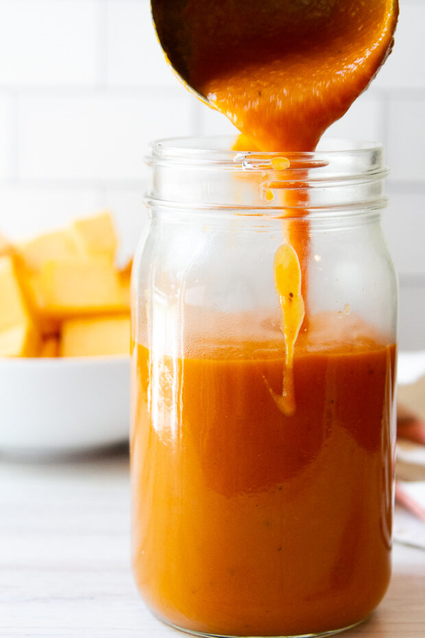 Butternut Squash Pasta Sauce being ladled in a glass mason jar.