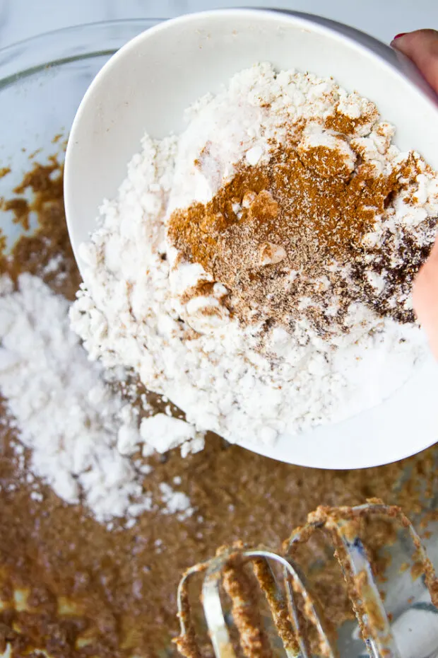 A bowl full of gluten free flour and spices being added to the wet ingredients.