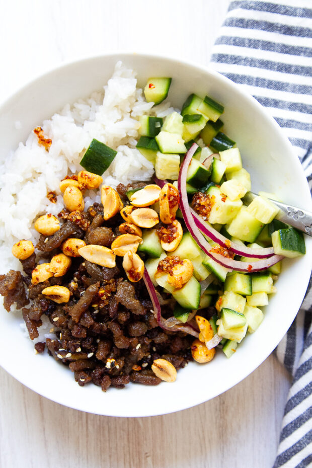Spicy ground turkey bowl with coconut rice, marinated cucumbers, peanuts, and chili crunch.