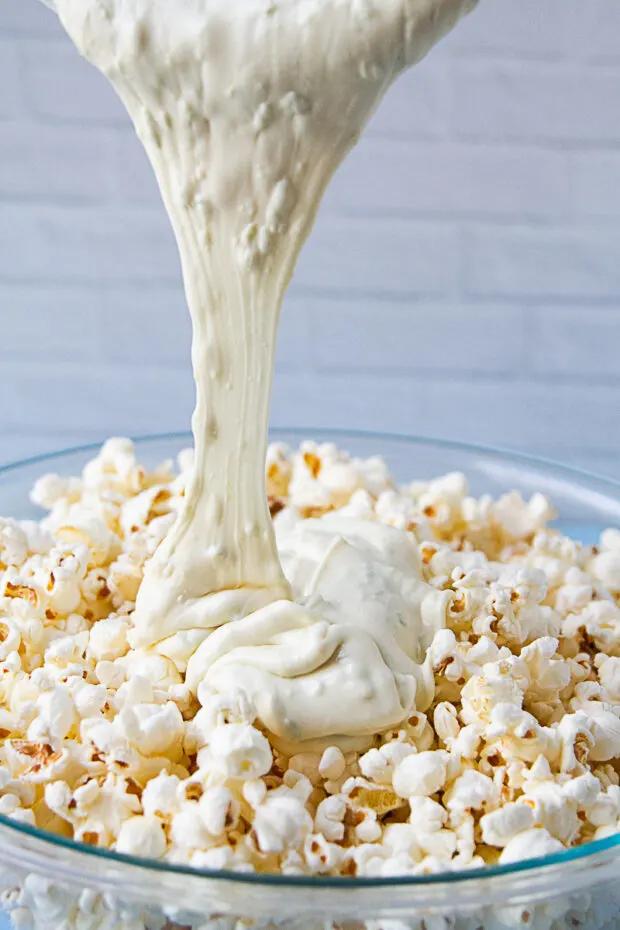 White chocolate poured over the bowl of popcorn.
