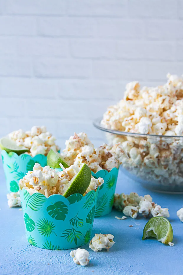 Little festive blue cups with the finished popcorn and a lime wedge in each.