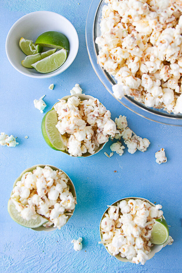 Little cups with toasted coconut popcorn -- each has a lime wedge.