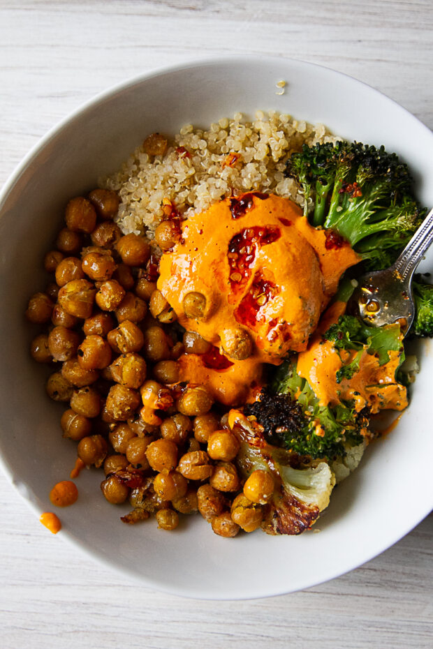 Quinoa bowl with roasted broccoli, cauliflower, and vegan roasted red pepper sauce.