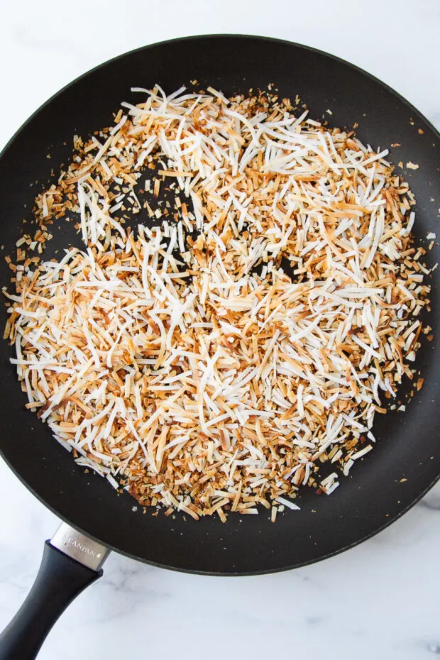 Nonstick skillet with toasted shredded coconut.
