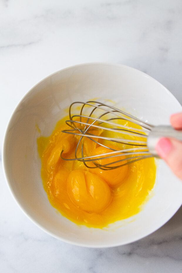 Egg yolks whisked in a bowl.