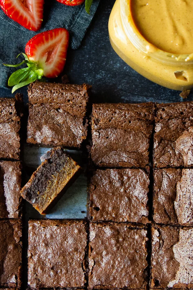 Brownies cut into squares -- one has been turned on its side to show the layers.