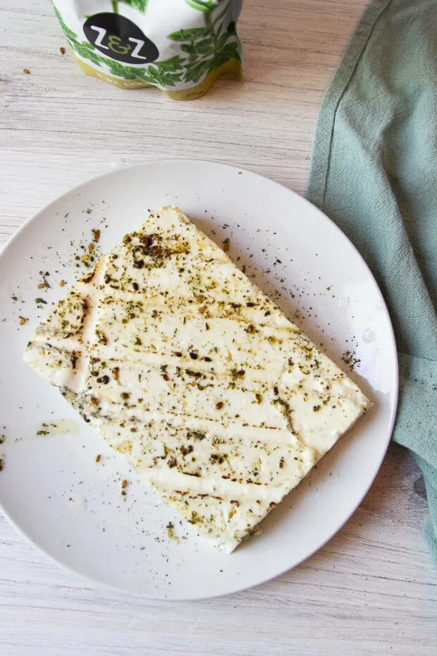 Block of feta that's been seasoned and grilled.