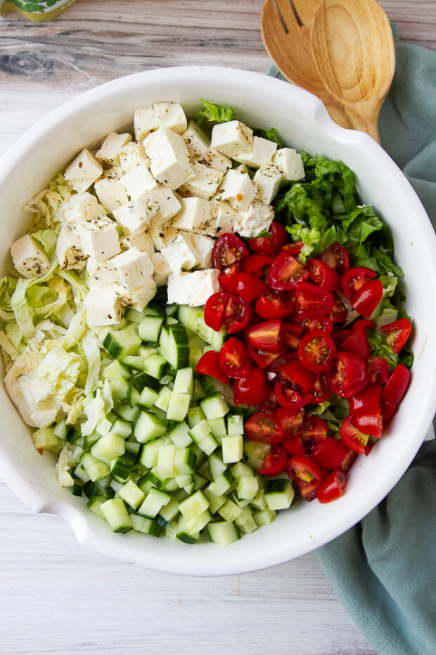 Salad with chopped tomatoes, cucumbers, and seasoned grilled feta over lettuce.
