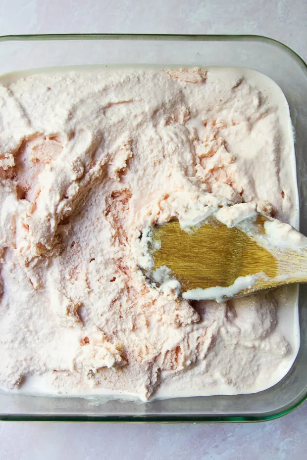 Strawberry Frozen Greek Yogurt in a 8x8 glass baking dish ready to be placed in the freezer.