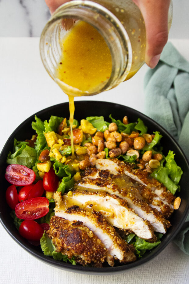 Honey mustard vinaigrette poured over the pretzel crusted chicken salad.