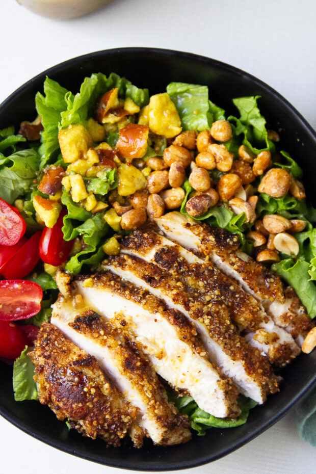 Pretzel Crusted Chicken Salad with Honey Mustard Vinaigrette topped with peanuts and pretzels.