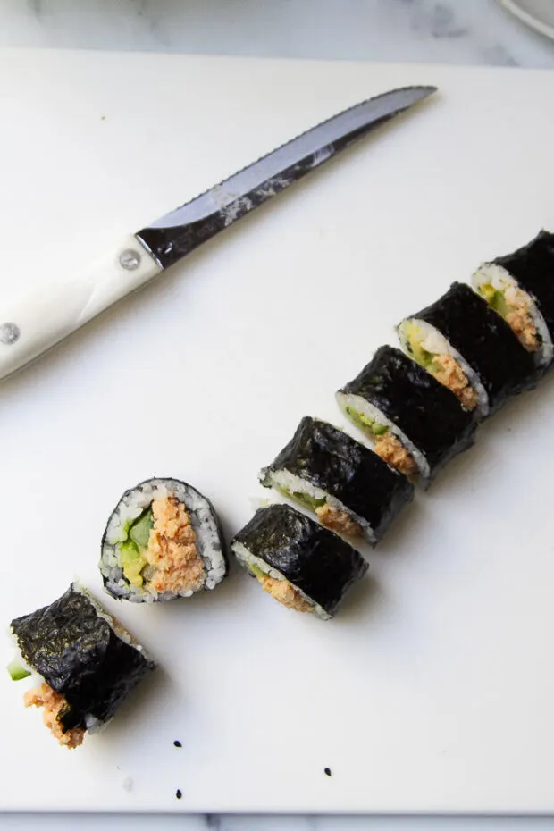 Sushi roll sliced with a serrated knife into small pieces.