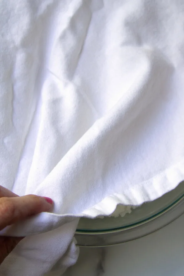 Bowl of rice covered with a tea towel.