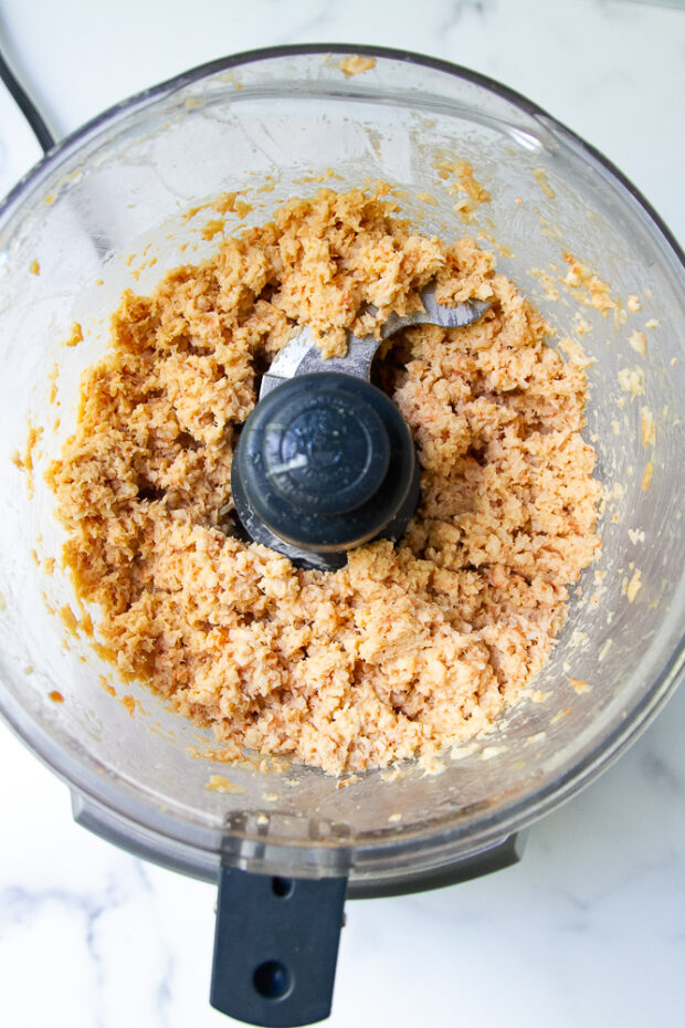 View of the inside of a food processor with spicy shrimp salad.