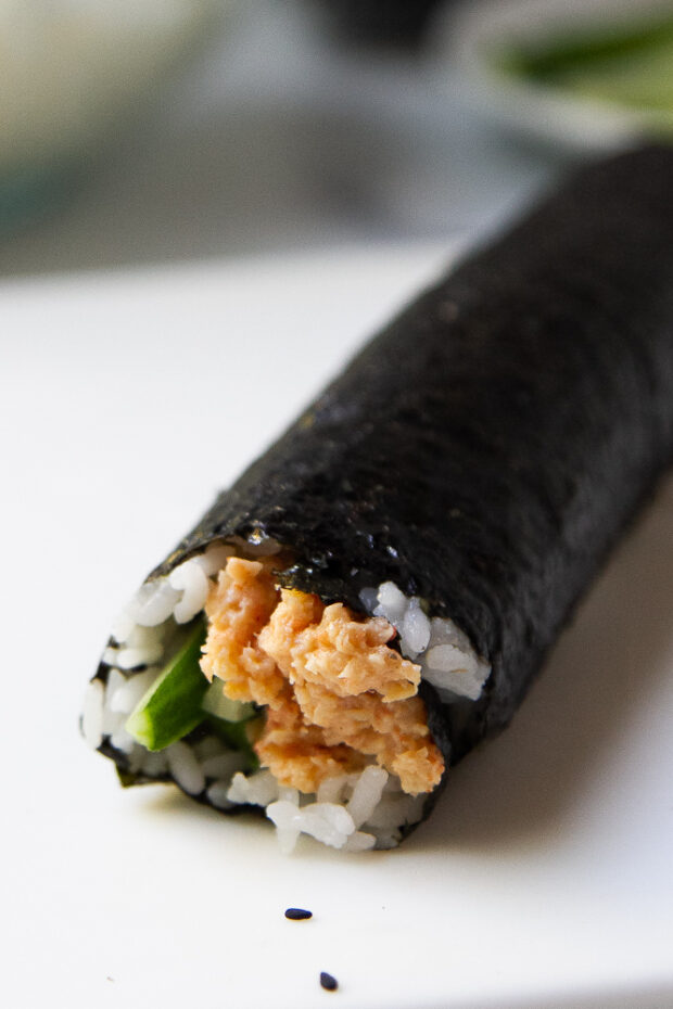 View of the tightly rolled sushi roll before slicing.