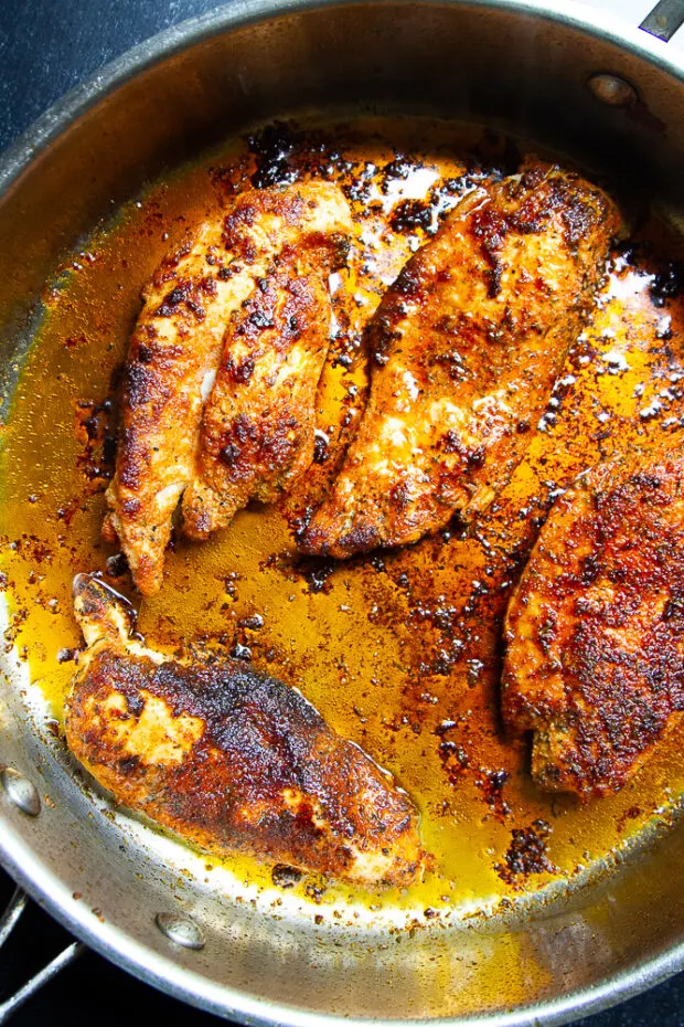 Blackened chicken in a skillet.