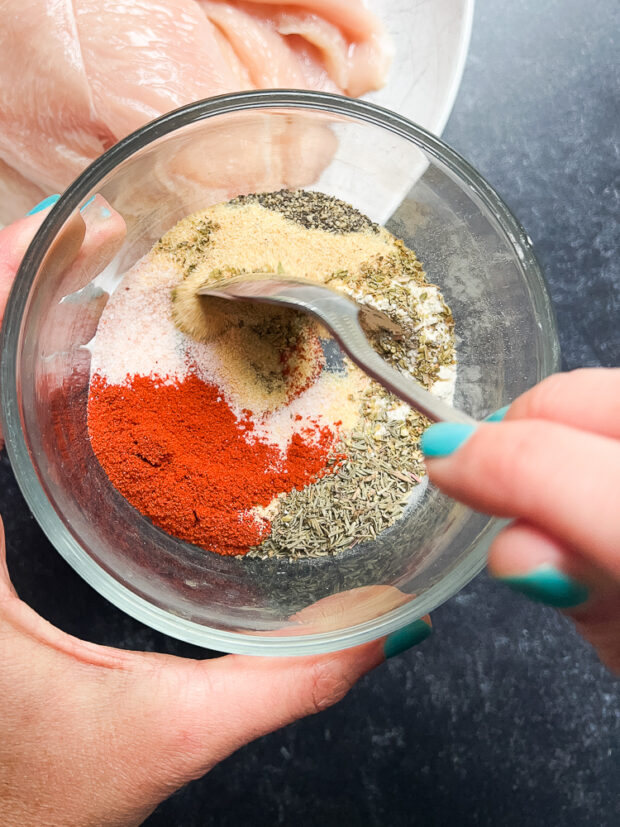 Small glass bowl with several seasonings being mixed together.