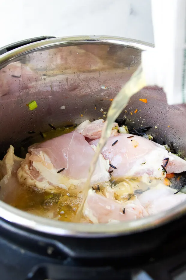 Chicken broth added to the pot along with the chicken and wild rice.