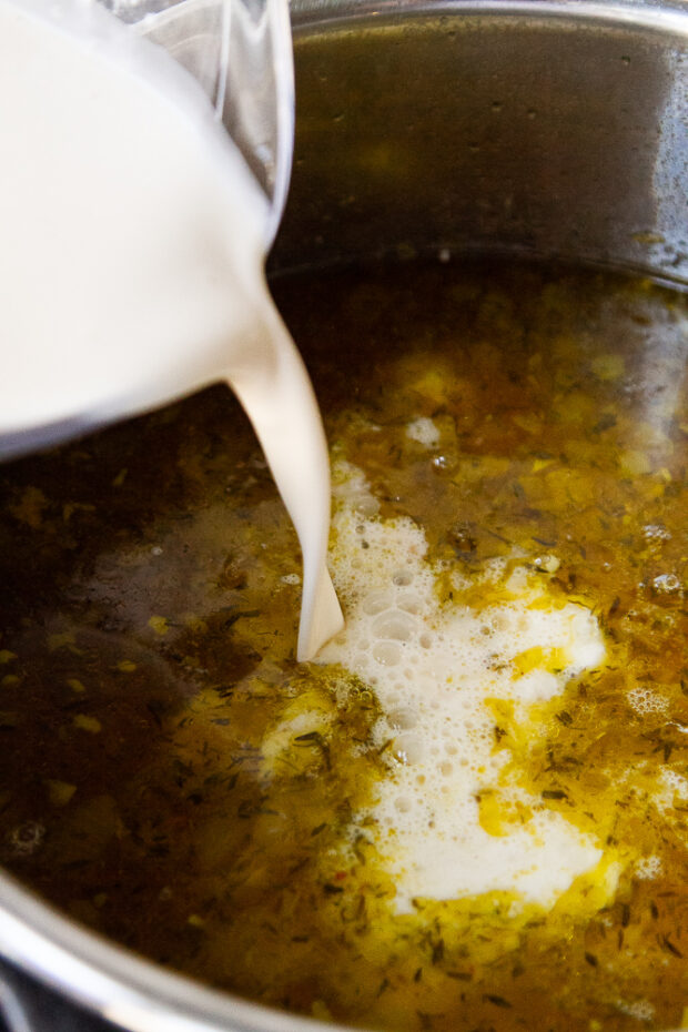 Cream and thickener being added to the hot finished soup.