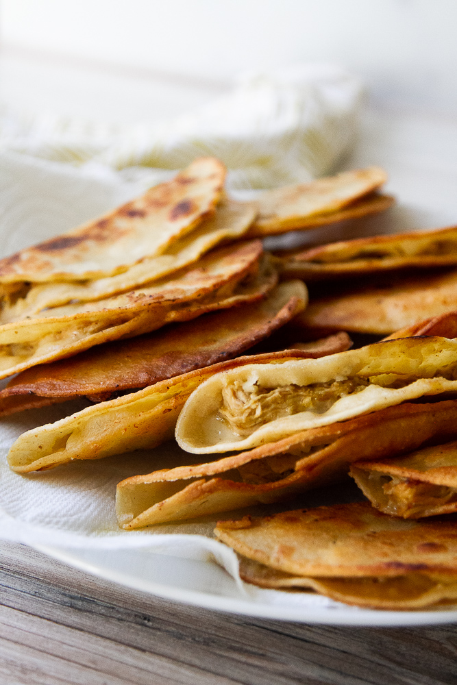 Crispy chicken tacos on a plate.