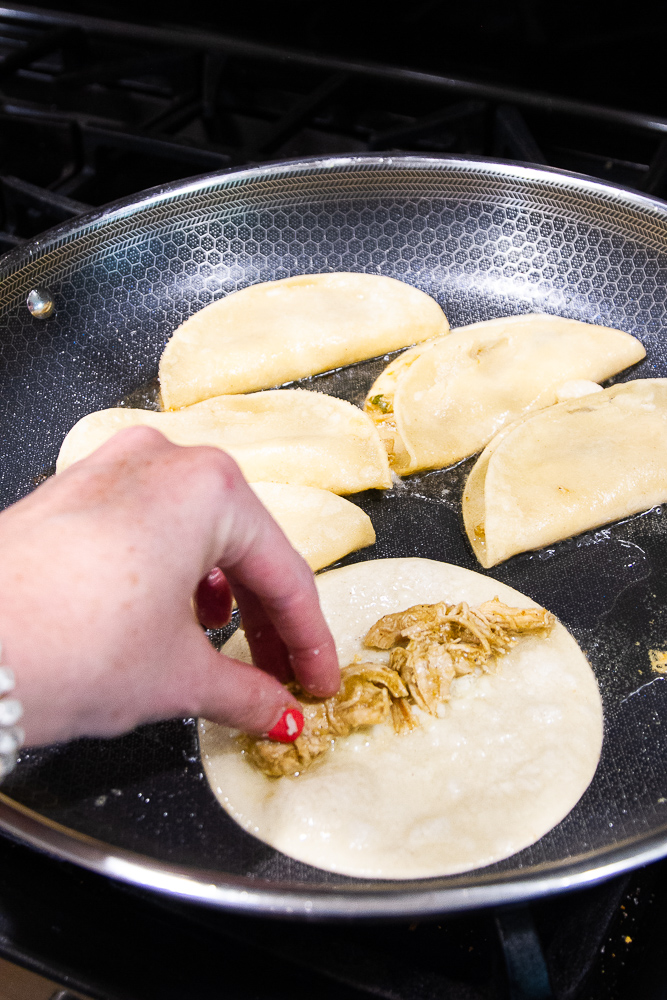 Crispy Chicken tacos cooking in a pan.