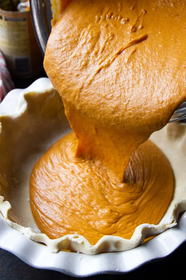 Pumpkin pie filling poured into a gluten free pie crust.