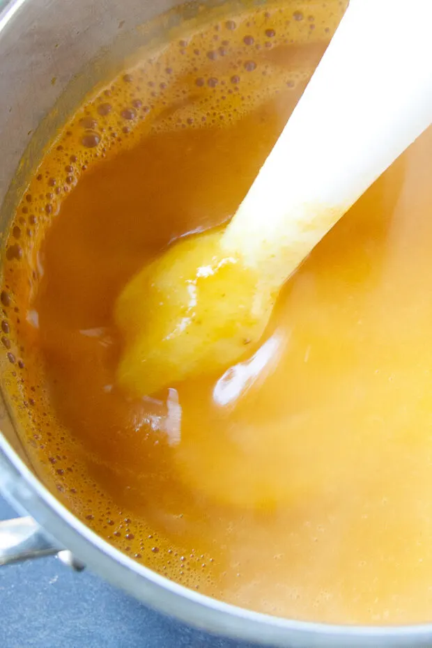 Soup blending using an immersion blender.