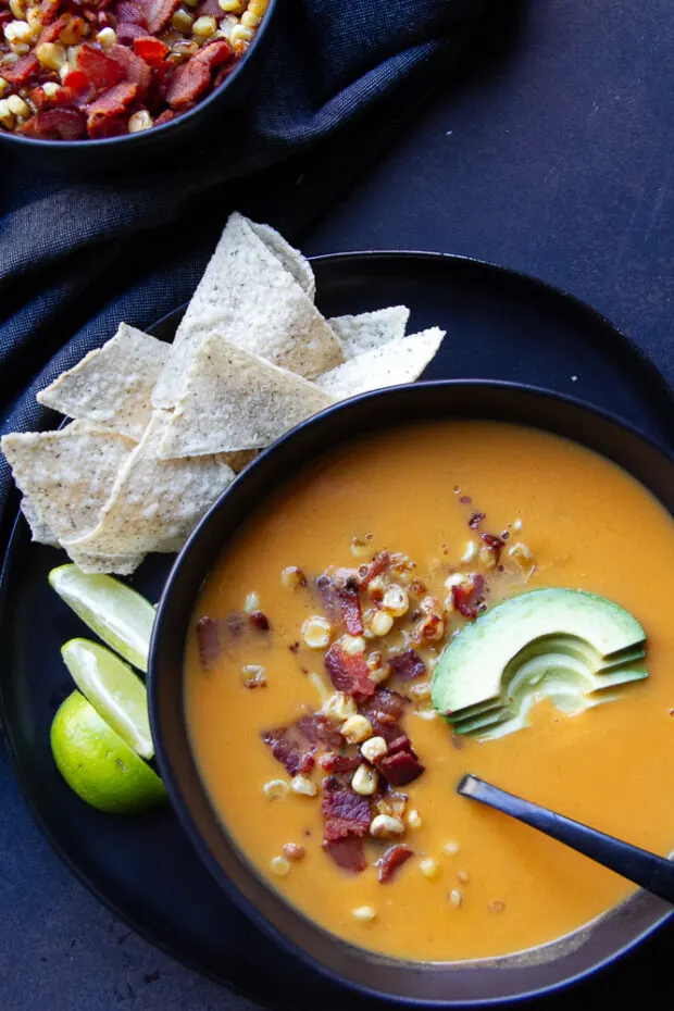 Black bowl with finished soup and garnishes.