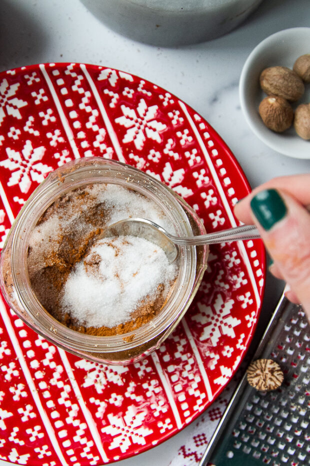 Stirring the ingredients for cinnamon sugar recipe in a small glass jar.