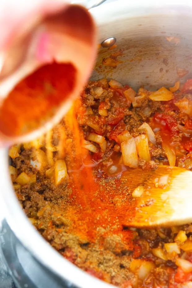 Adding spices to the cooked chorizo and onions.