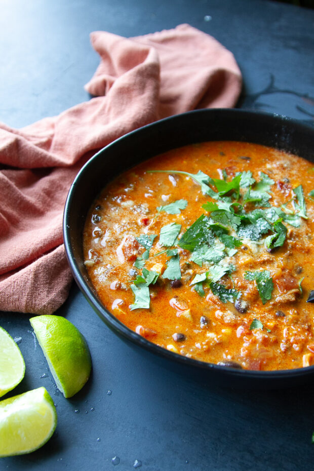 Another shot of the pumpkin chorizo chili in a black bowl garnished with fresh cilantro.