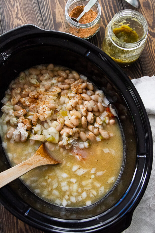 View of crock pot with ingredients for the white bean chili, but hasn't been cooked yet.