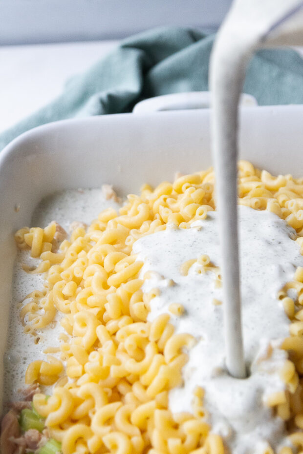 Pouring the cottage cheese sauce into the dish with the tuna and cooked pasta.