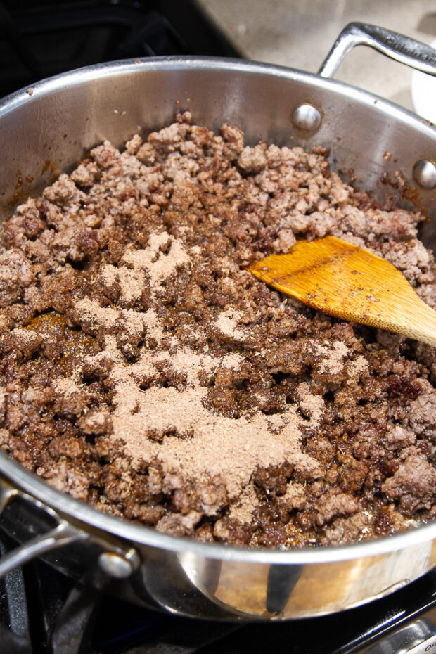 Taco seasoning has been added to the ground beef in the skillet.