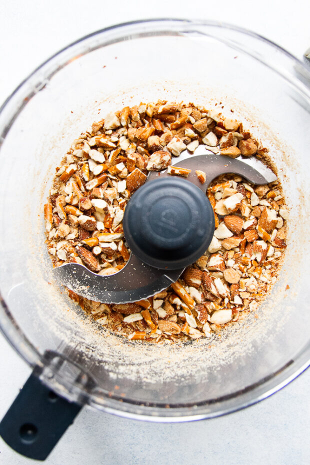 Pretzels and almonds in a food processor and have been chopped roughly.